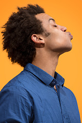 Image showing Portrait of attractive afro man with kiss isolated over orange background