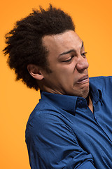 Image showing Let me think. Doubtful pensive man with thoughtful expression making choice against orange background