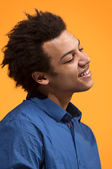 Image showing The happy business man standing and smiling against orange background.