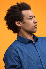 Image showing The serious businessman standing against orange background.