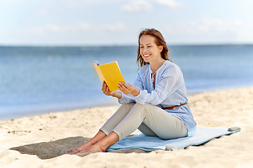 Image showing happy smiling woman reading book on summer beach