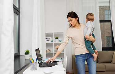 Image showing mother with baby and laptop working at home