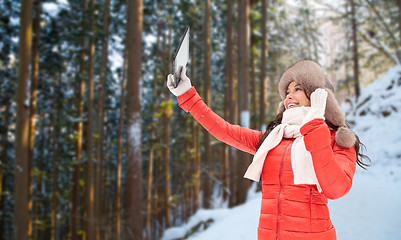 Image showing woman in winter fur hat with tablet pc outdoors