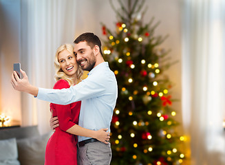 Image showing couple taking selfie by smartphone on christmas