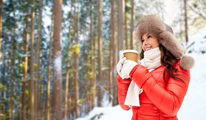 Image showing woman in fur hat with coffee over winter forest