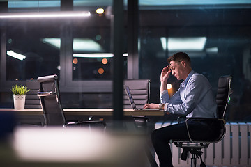 Image showing man working on laptop in dark office