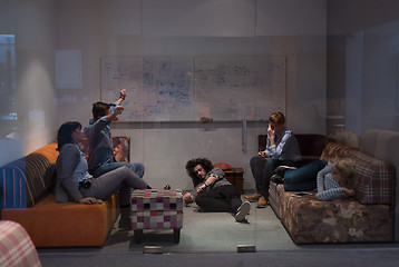 Image showing software developers sleeping on sofa in creative startup office