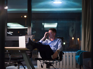 Image showing businessman sitting with legs on desk at office