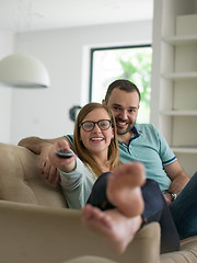 Image showing Young couple on the sofa watching television