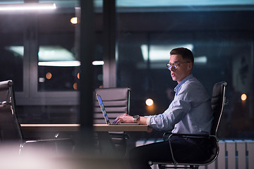 Image showing man working on laptop in dark office