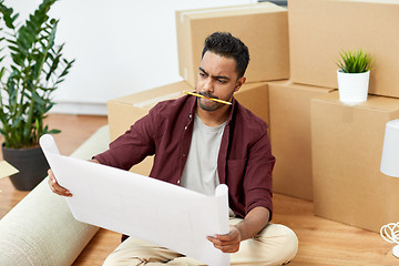 Image showing man with blueprint and boxes moving to new home