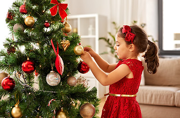 Image showing little girl decorating christmas tree at home