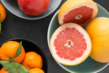 Image showing close up of citrus in bowls fruits on stone table