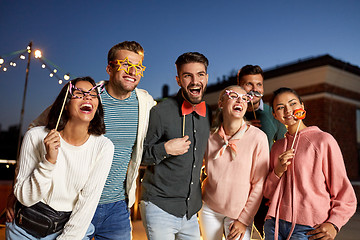 Image showing happy friends with party props at rooftop