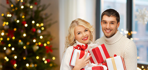 Image showing happy couple with christmas gifts at home