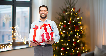 Image showing happy man with christmas gifts at home