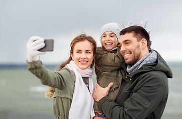 Image showing family taking selfie by smartphone on autumn beach