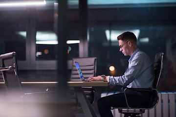 Image showing man working on laptop in dark office