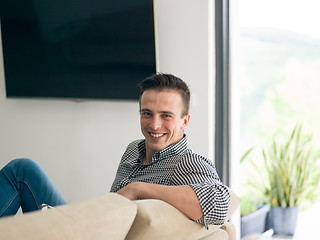 Image showing man on sofa using tablet computer