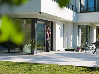 Image showing man drinking coffee in front of her luxury home villa