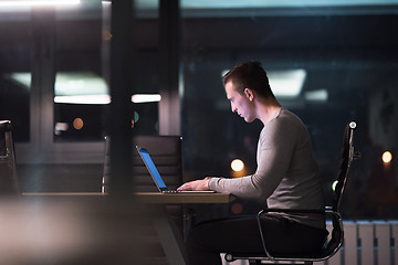 Image showing man working on laptop in dark office