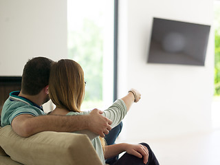 Image showing Young couple on the sofa watching television