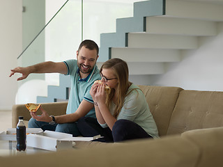 Image showing couple eating pizza in their luxury home villa