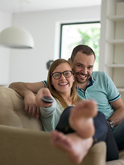 Image showing Young couple on the sofa watching television