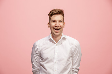 Image showing The happy business man standing and smiling against pink background.