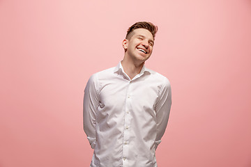 Image showing The happy business man standing and smiling against pink background.