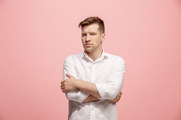 Image showing The serious businessman standing and looking at camera against pink background.