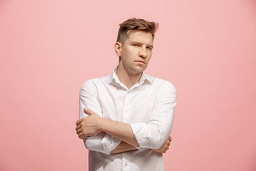 Image showing The serious businessman standing and looking at camera against pink background.