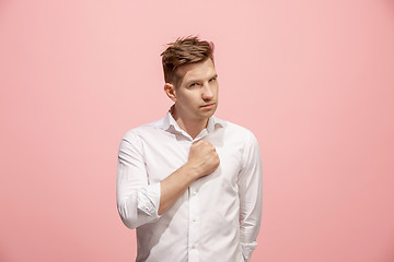 Image showing Beautiful male half-length portrait isolated on pink studio backgroud. The young emotional surprised man