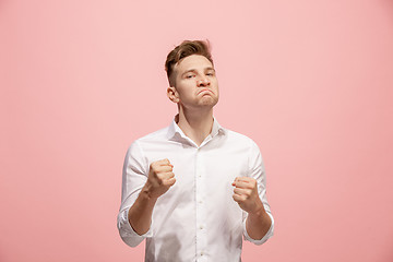 Image showing The young emotional angry man screaming on pink studio background