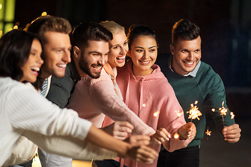 Image showing happy friends with sparklers at rooftop party