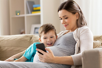 Image showing pregnant mother and son with smartphone at home