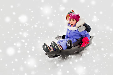 Image showing kids sliding on sled down snow hill in winter