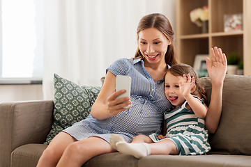 Image showing pregnant mother and daughter having video chat