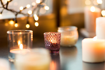 Image showing candles burning on window sill with garland lights