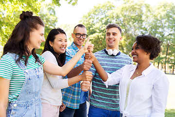 Image showing happy friends making thumbs up in park