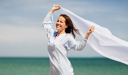 Image showing happy woman with shawl waving in wind on beach