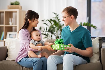 Image showing mother with baby giving birthday present to father