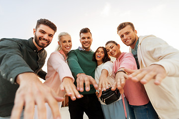 Image showing happy friends reaching hands to you