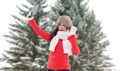 Image showing woman with tablet pc over fir trees in winter