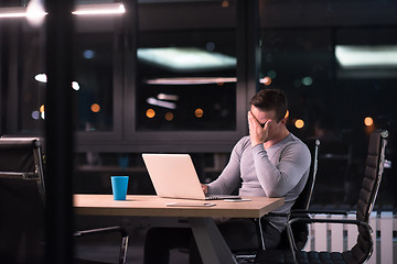 Image showing man working on laptop in dark office