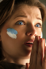 Image showing Portrait of a woman with the flag of the Argentina painted on her face.