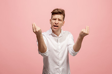 Image showing Beautiful male half-length portrait isolated on pink studio backgroud. The young emotional surprised man