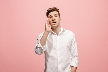 Image showing Isolated on pink young casual man shouting at studio