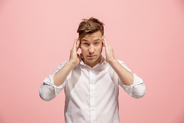 Image showing Man having headache. Isolated over pink background.