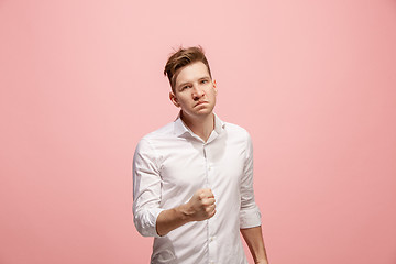 Image showing The young emotional angry man screaming on pink studio background